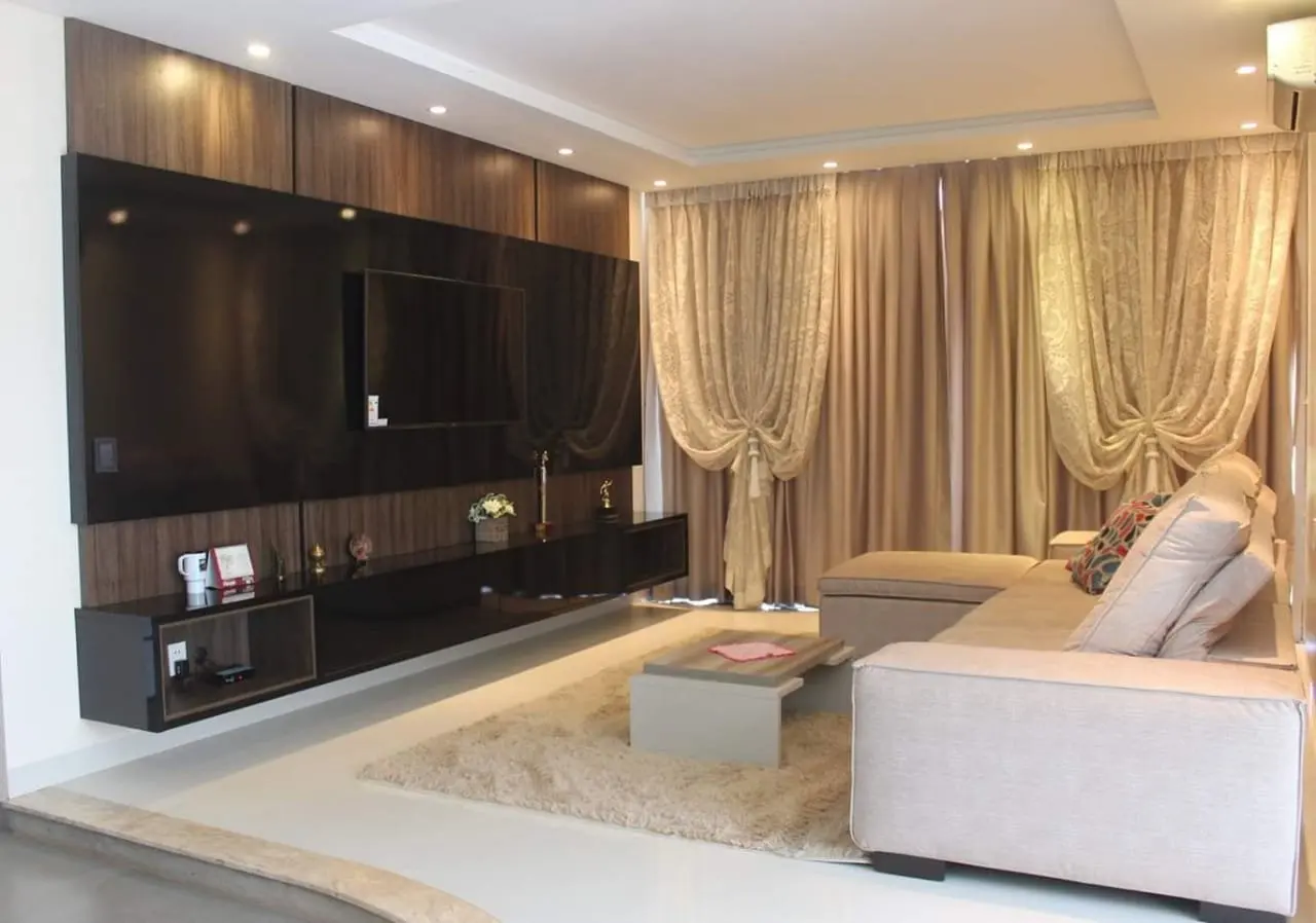Living con cortinas de tela y un mueble a medida para el televisor