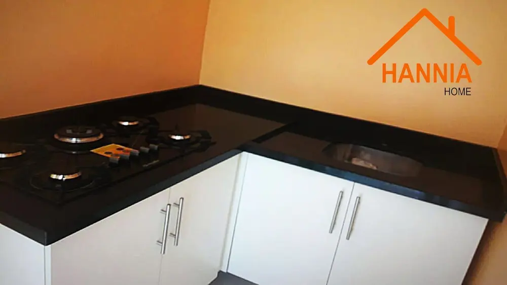 Cocina con mueble blanco y mesada negra